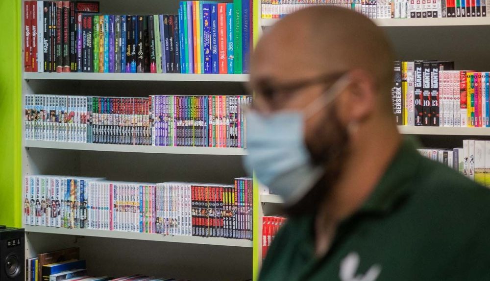 Álvaro durante el encuentro con una estantería de manga al fondo.