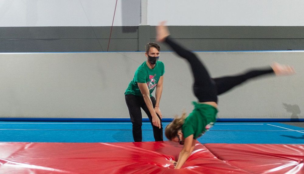 Una chica realiza una acrobacia en la colchoneta. 