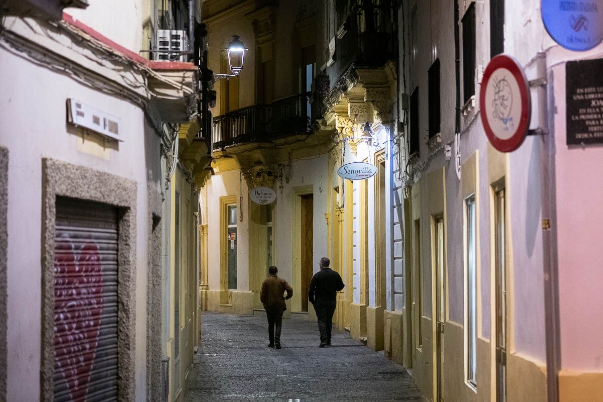 Dos personas caminan por la calle poco antes del toque de queda.