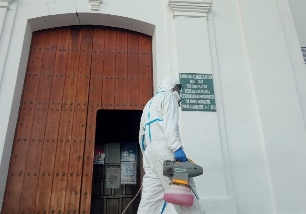 Un operario desinfecta frente a la iglesia de Torre Alháquime.