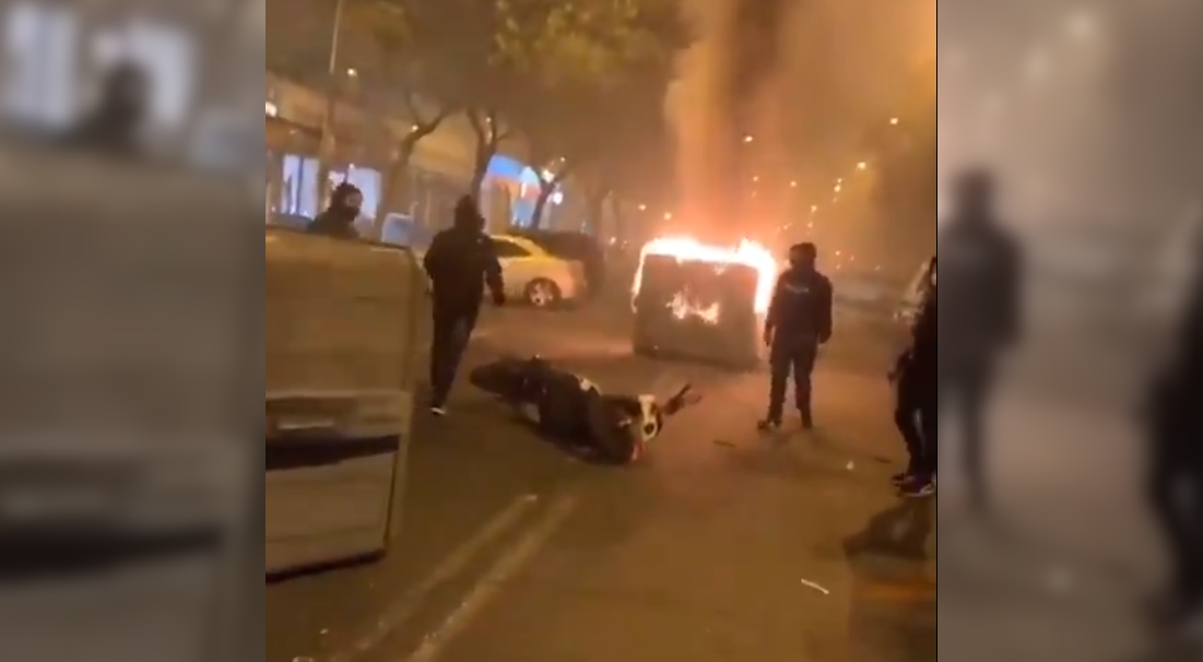 Un momento de las protestas en Pino Montano contra el toque de queda, con un contenedor ardiendo y una moto tirada en la carretera, en una imagen que circuló la madrugada en redes.