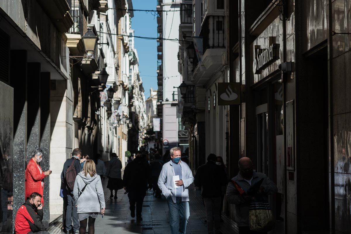 Varias personas pasean por Cádiz, con mascarillas frente al covid.