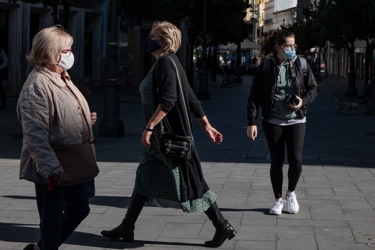 Varias personas pasean con mascarilla.