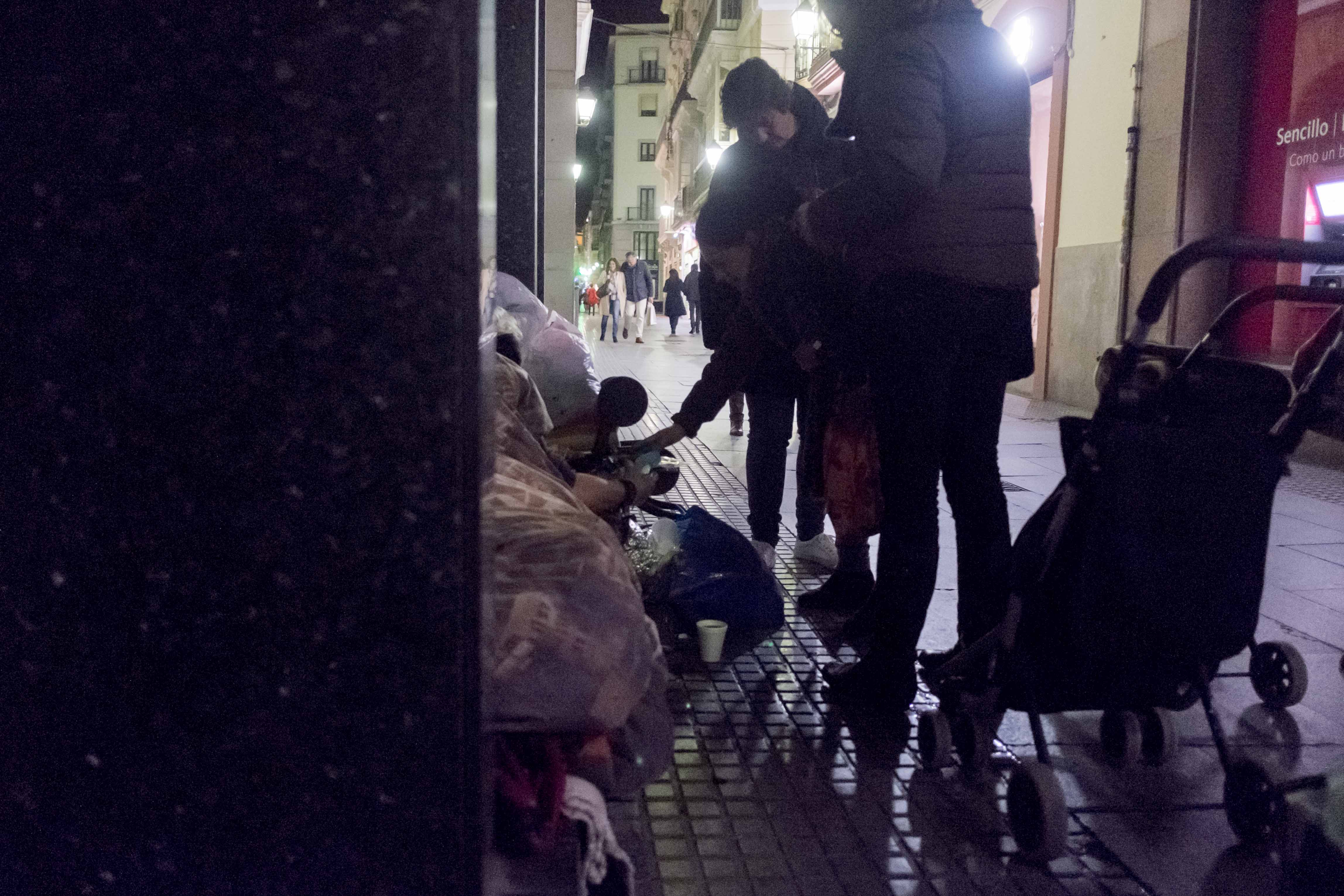 Voluntarias de la asociación Calor en la Noche ofreciendo comida a un sintecho. FOTO: MANU GARCÍA.