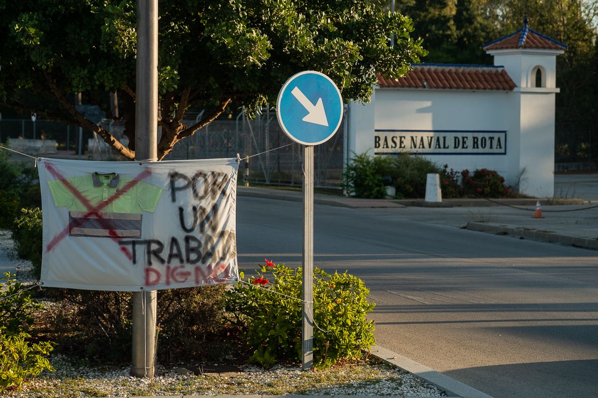 Entrada a la Base de Rota, con una pancarta en protesta por sus condiciones laborales.