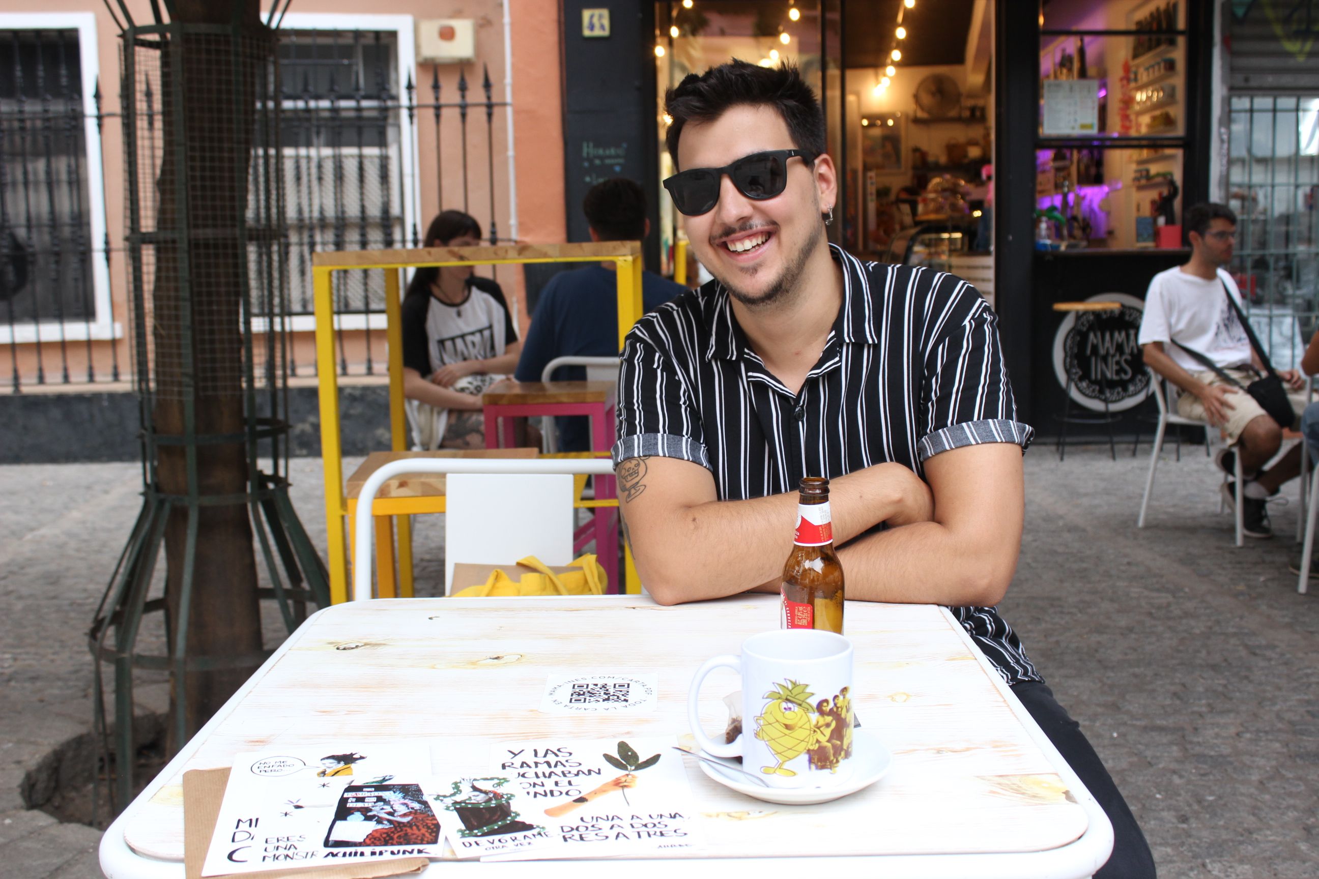 Andrés en una terraza con algunas de sus láminas. Autora: Nieve Castro