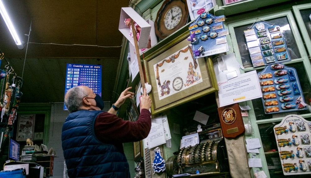 Miguel muestra el reloj de madera que conserva la tienda.