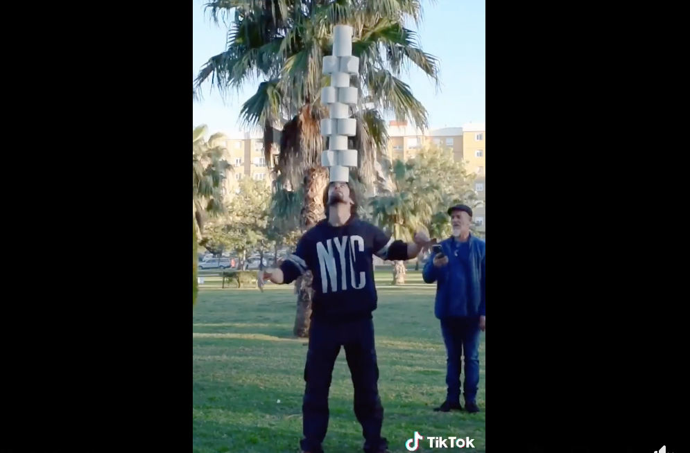 El malabarista isleño Marcos Ruiz, sosteniendo rollos de papel higiénico con la frente.