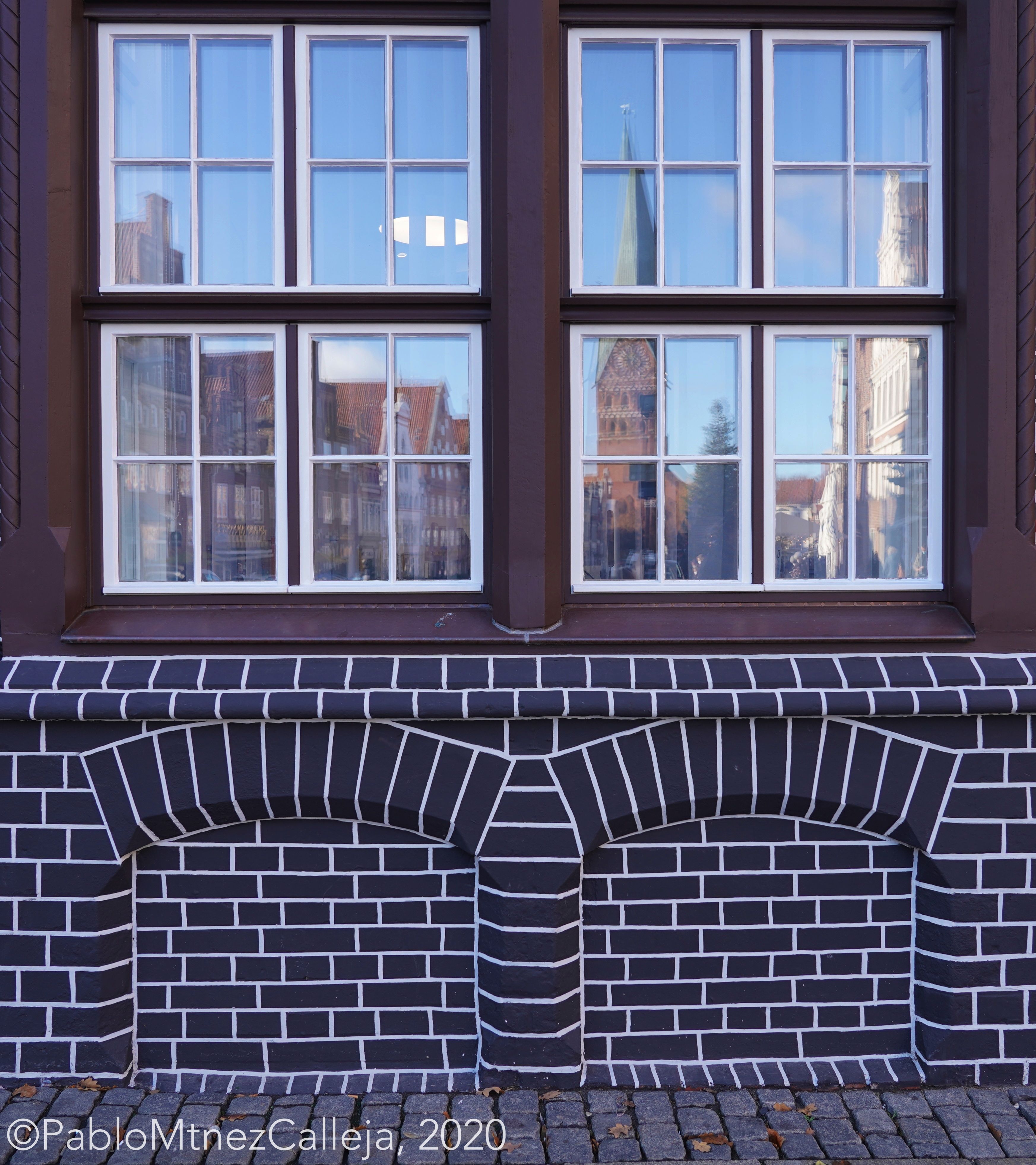 Cámara de Comercio con la iglesia de San Juan reflejada en su ventana