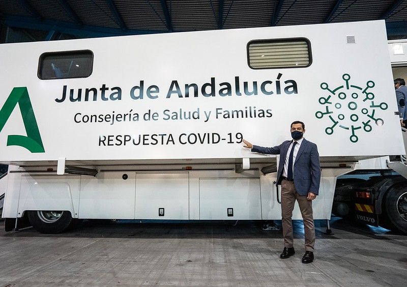 El presidente de la Junta de Andalucía, Juan Manuel Moreno, junto a un camión itinerante para realizar cribados masivos.