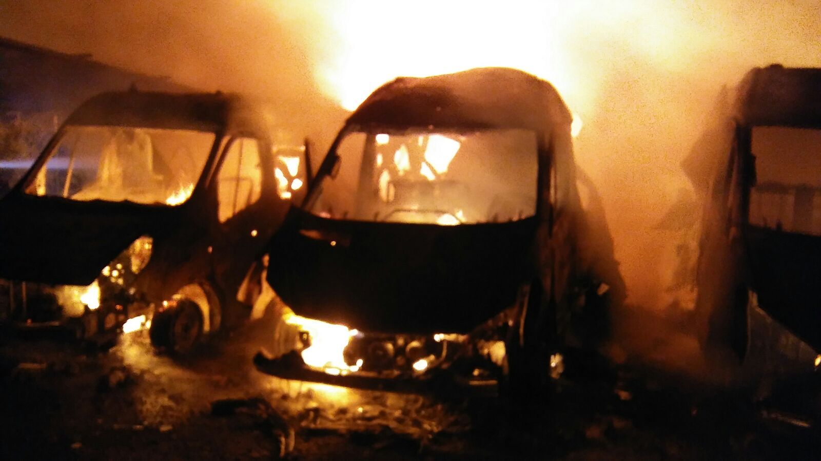Ambulancias ardiendo en el aparcamiento de la empresa en la zona del Cortijo Real. 