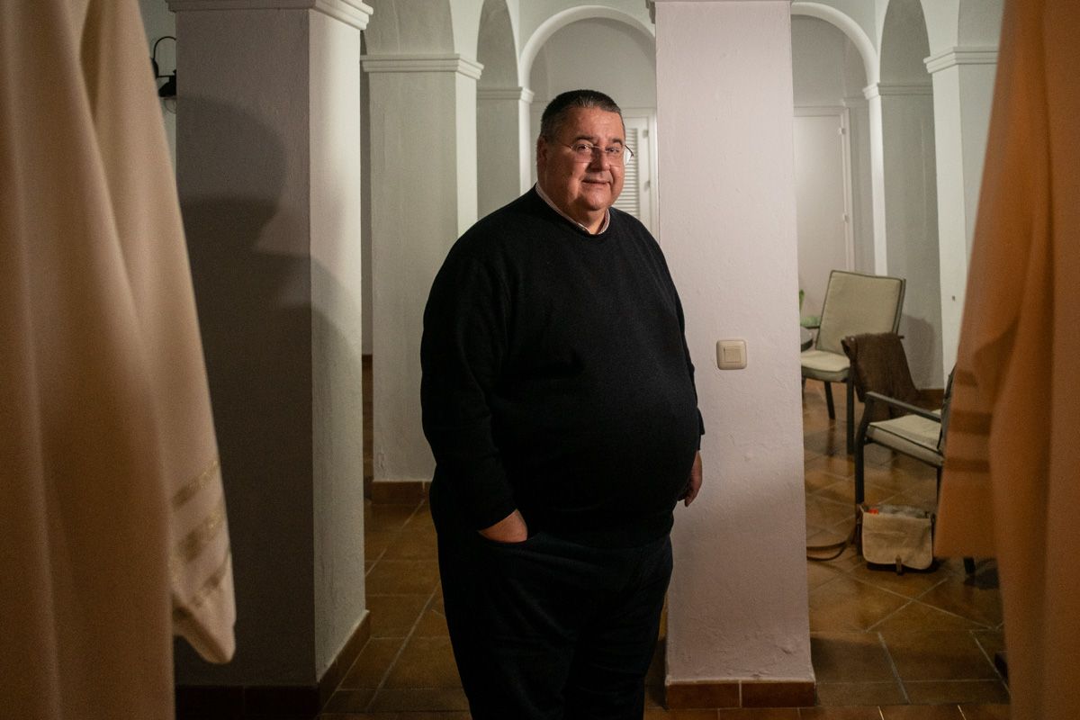 El ex cura de Conil, Rafael Vez, en una entrevista, en su casa, flanqueado por dos túnicas colgadas de unas puertas. FOTO: MANU GARCÍA