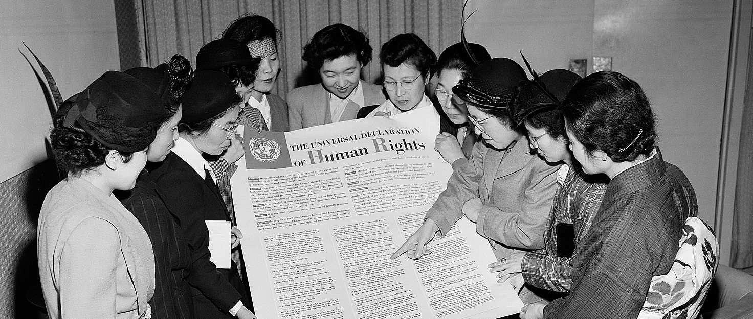 Varias personas leen la Declaración de Derechos Humanos en el pasado. FOTO: Amnistía