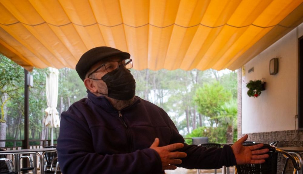 Brígido Mera, en su terraza de Las Aguilillas, en medio de una tromba. FOTO: MANU GARCÍA