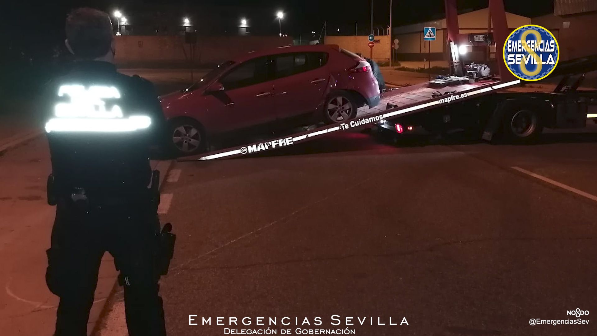 Un agente de Policía Local contempla cómo se retira el vehículo utilizado en la carrera ilegal.