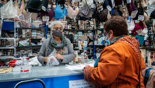 Una clienta conversa con Amalia mientras le pide unas camisetas. 