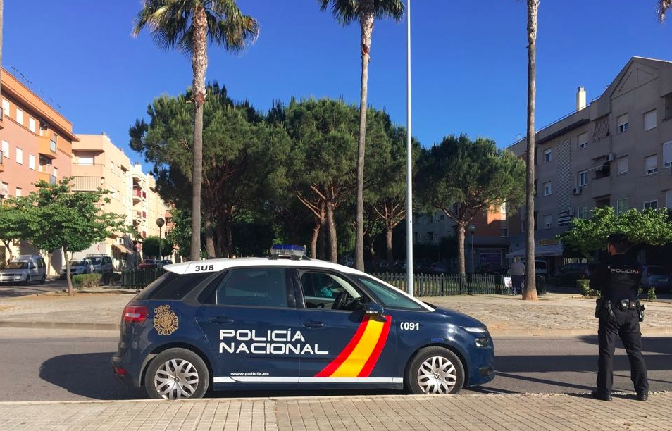 Un agente de la Policía Nacional, junto a un coche patrulla, en una imagen retrospectiva.
