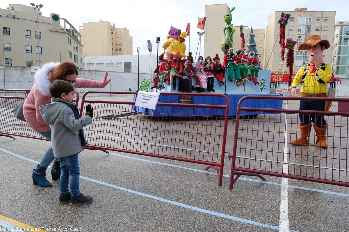 Un niño saluda a los personajes de las carrozas estáticas de los Reyes Magos en Cádiz. 