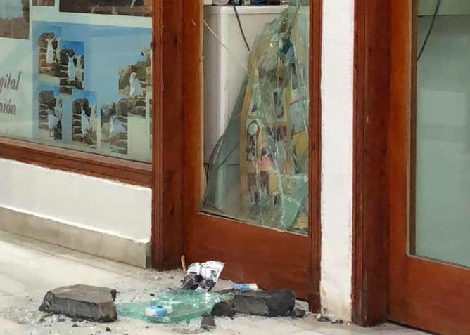 Cristales rotos y la piedra usada por los delincuentes para acceder al negocio. FOTO: LAVOZDELSUR.ES