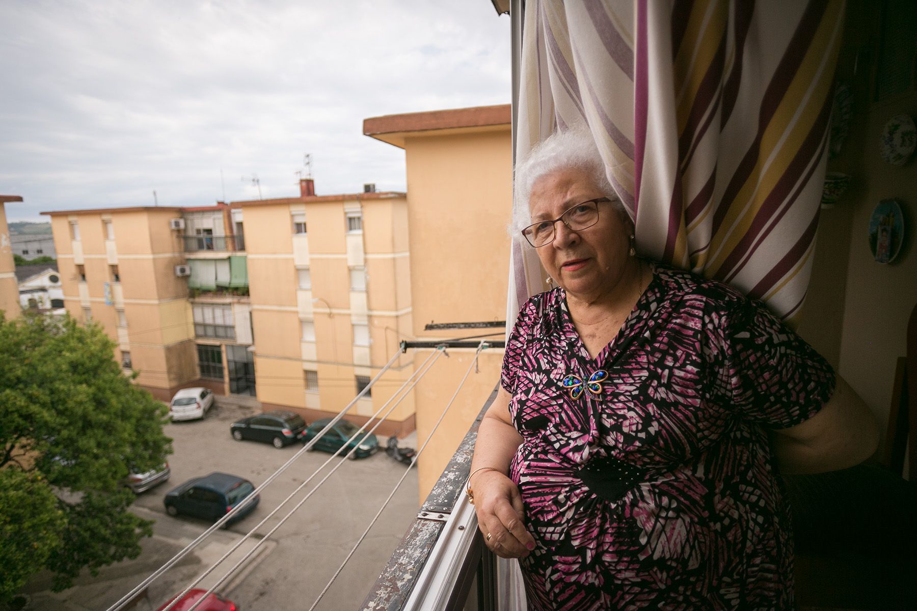 Pepa, vecina de la barriada Domecq, asomándose a su balcón: FOTO: JUAN CARLOS TORO.