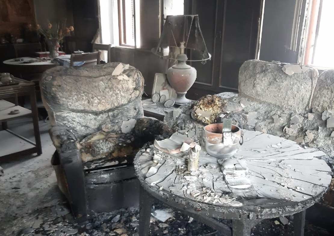 Estado en el que ha quedado el salón de la vivienda incendiada en Jimena, donde una mujer se ha visto afectada por inhalación de humo.