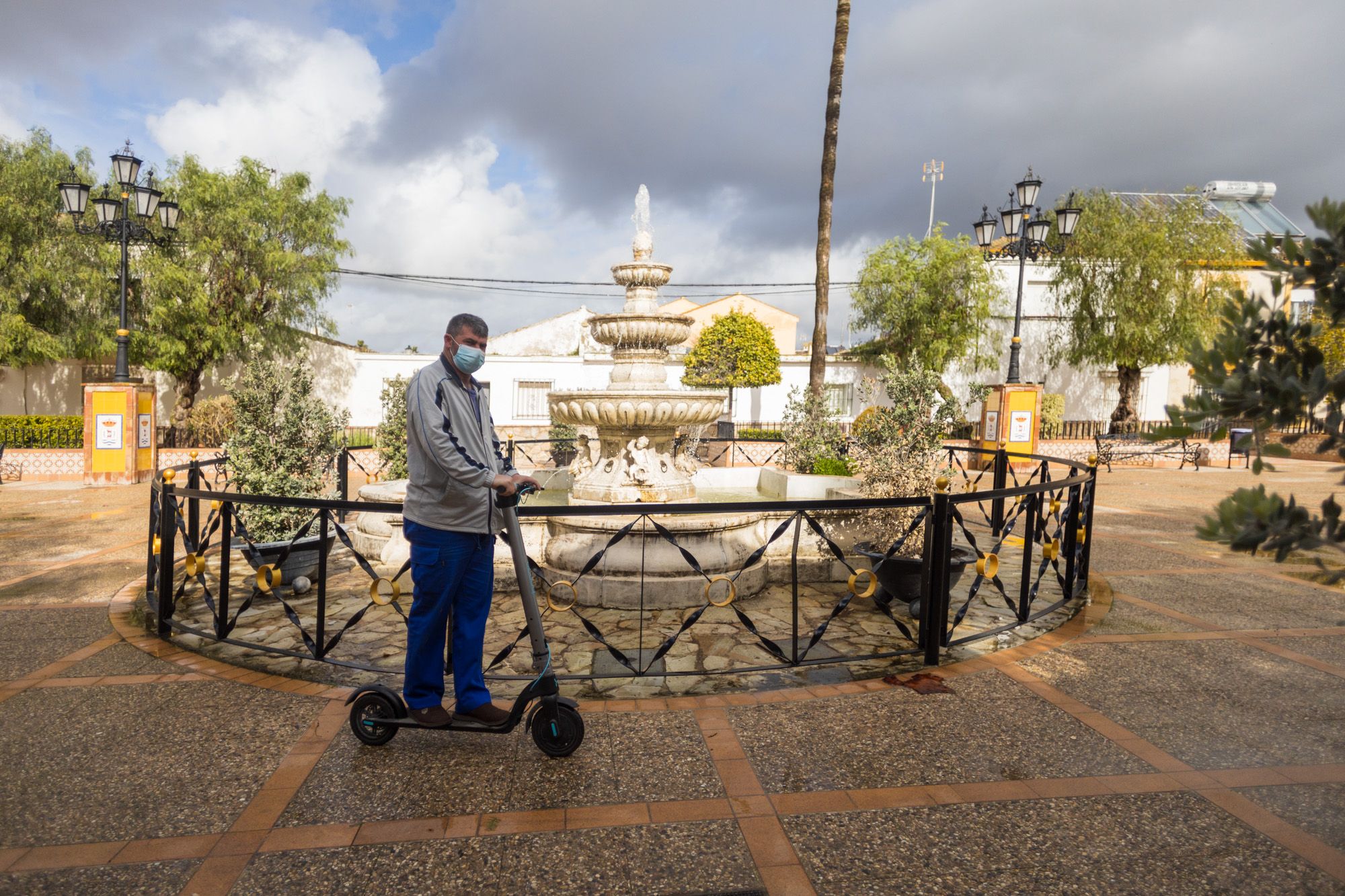 Un vecino pasa con su patinete por la plaza principal de Nueva Jarilla.
