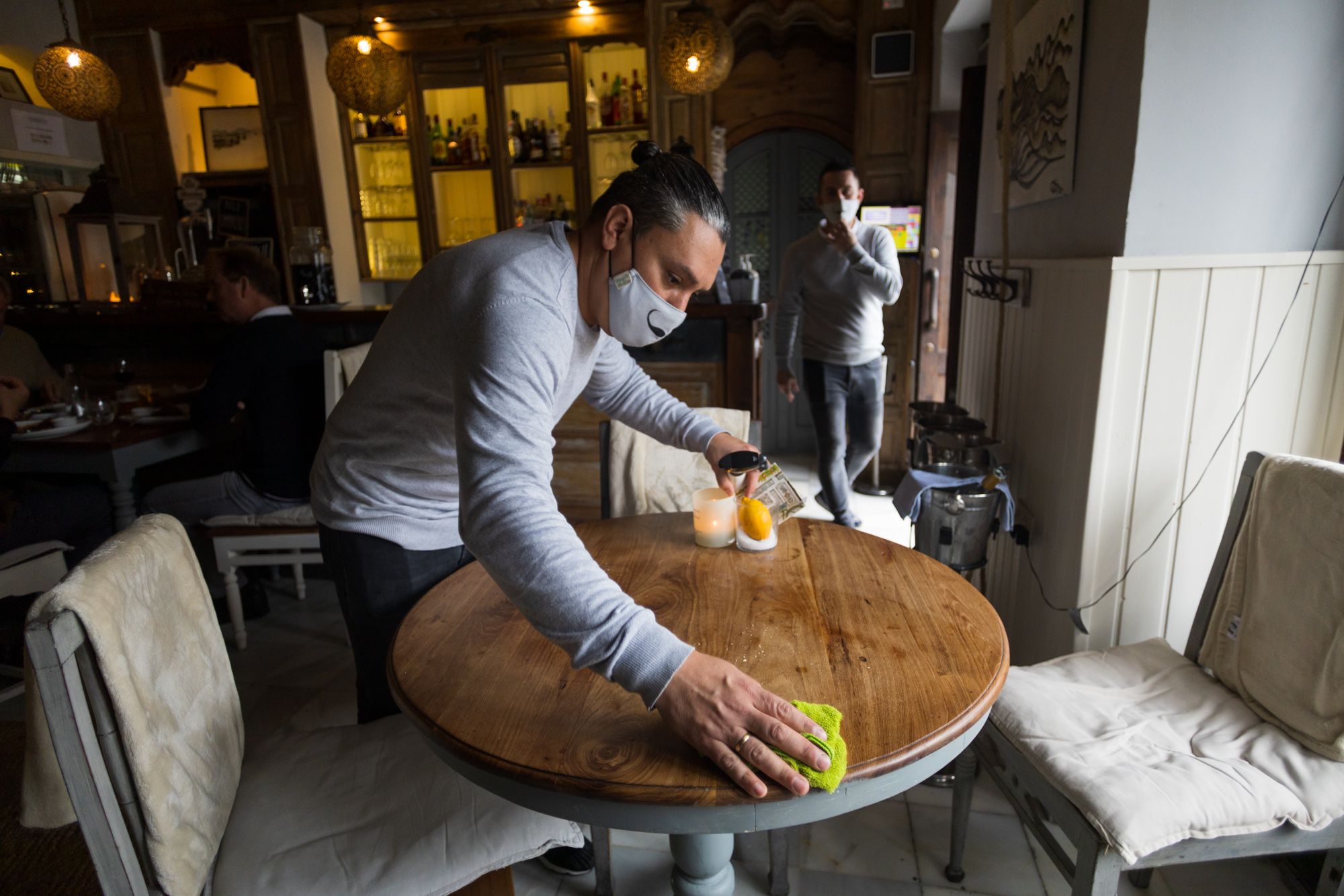 Un camarero limpia una mesa en Corredera 55, de Ellie Cormié. FOTO: JUAN CARLOS TORO