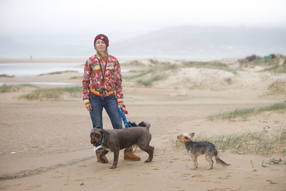 Eva Tomé, con sus perros, paseando por una playa de Tarifa.