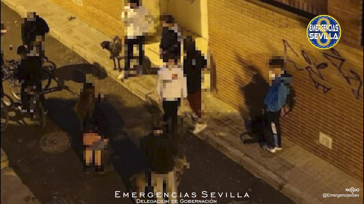 Estudiantes, que han tenido meses a los vecinos sin poder dormir bien, a las puertas del bloque de Los Remedios, en Sevilla. EMERGENCIAS SEVILLA