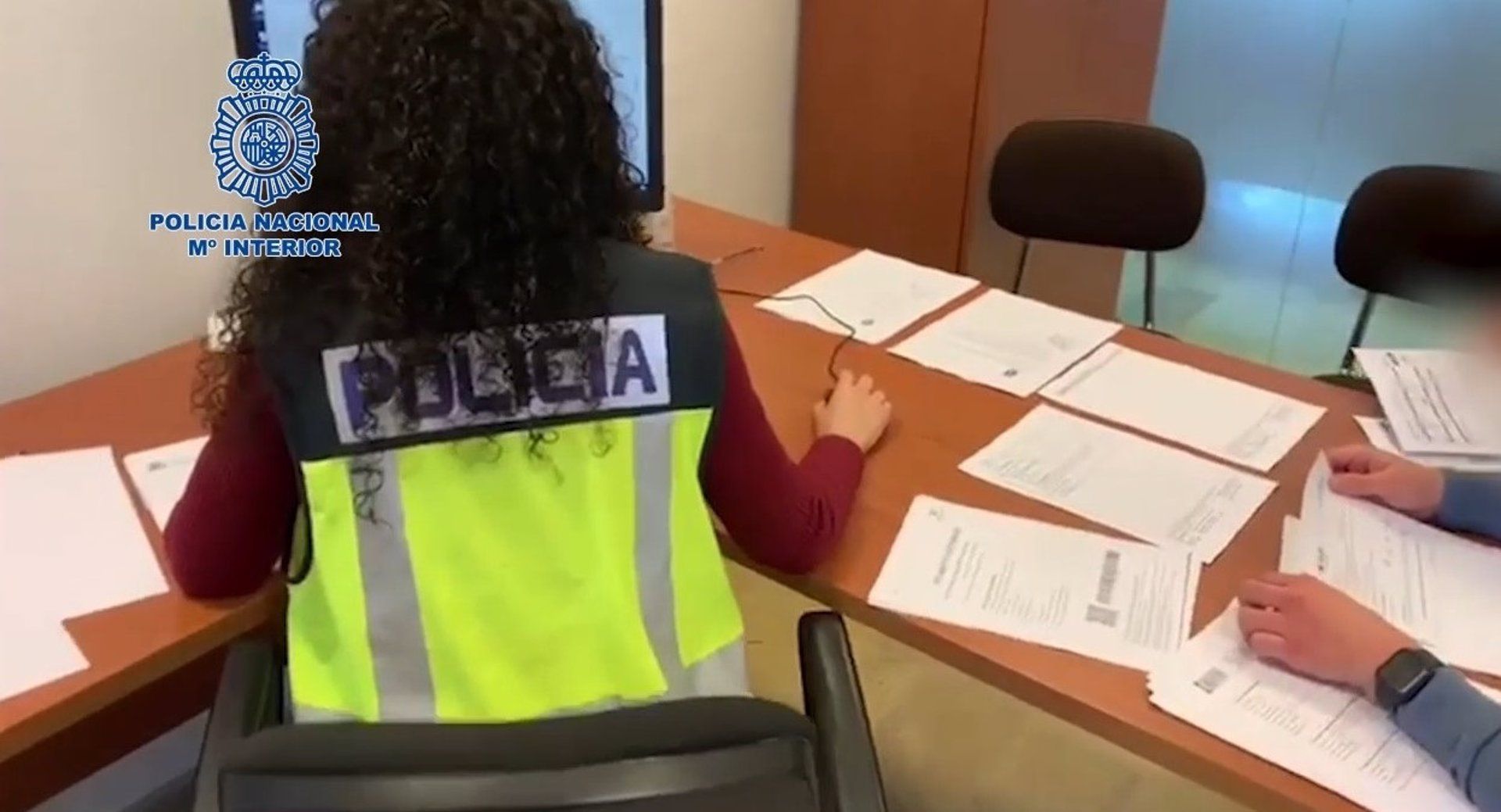 Una agente de Policía Nacional trabajando en la trama que falsificaba permisos de residencia.