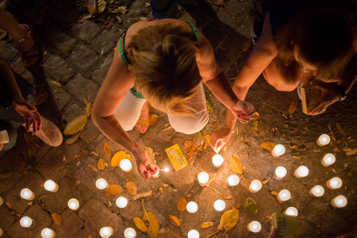 Unas jóvenes encienden velas en 'La noche de las candelas' de Aspanido. FOTO: MANU GARCÍA.