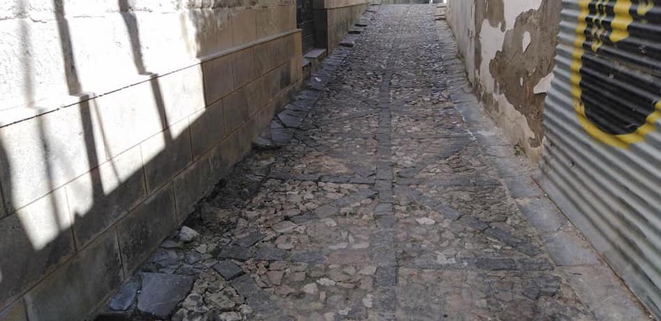 Una calle del centro de Jerez, con un hueco donde faltan losas de Tarifa.