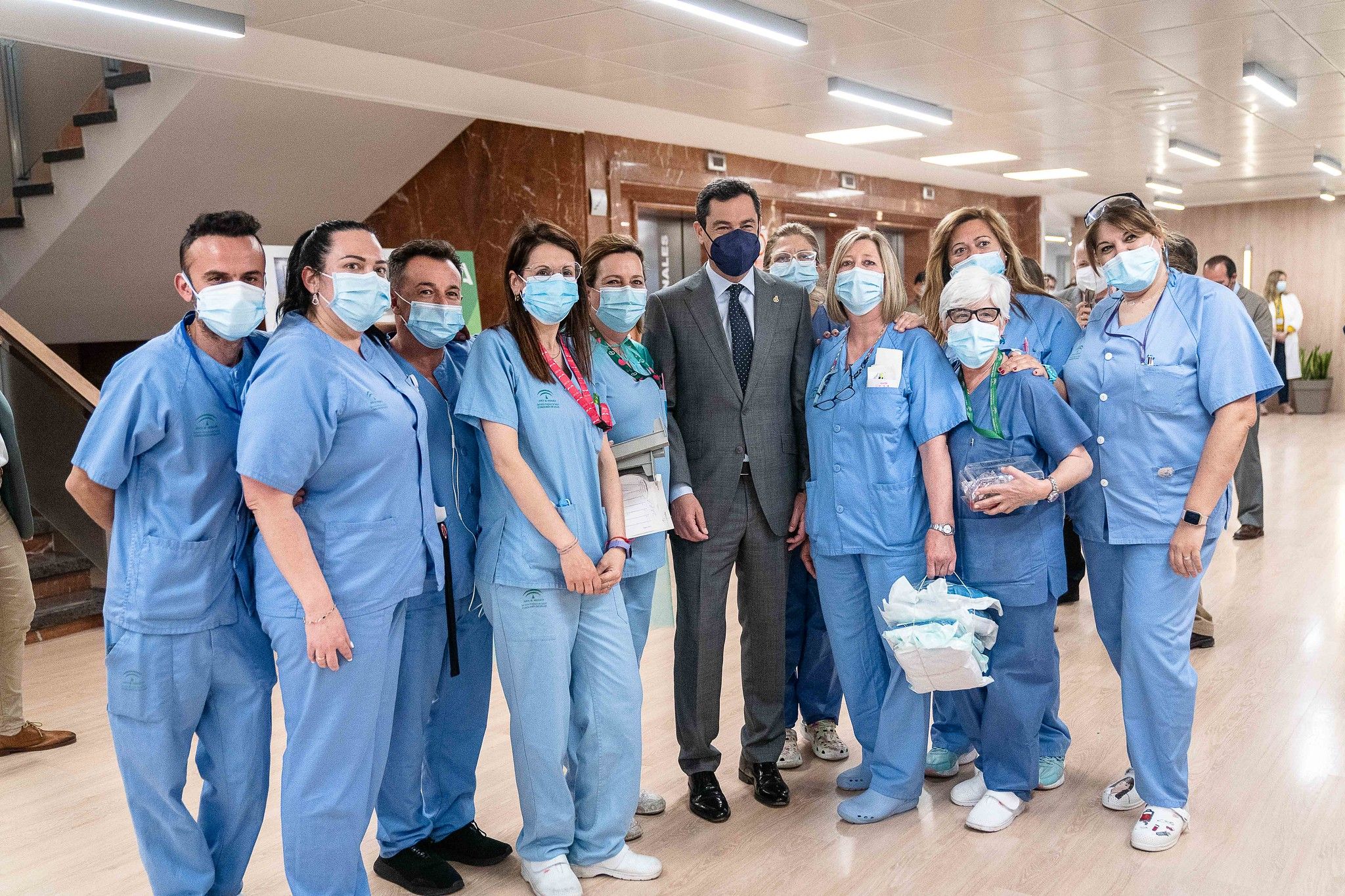 El presidente de la Junta, Juan Manuel Moreno Bonilla, posa con personal del Virgen Macarena, este lunes. JUNTA DE ANDALUCÍA