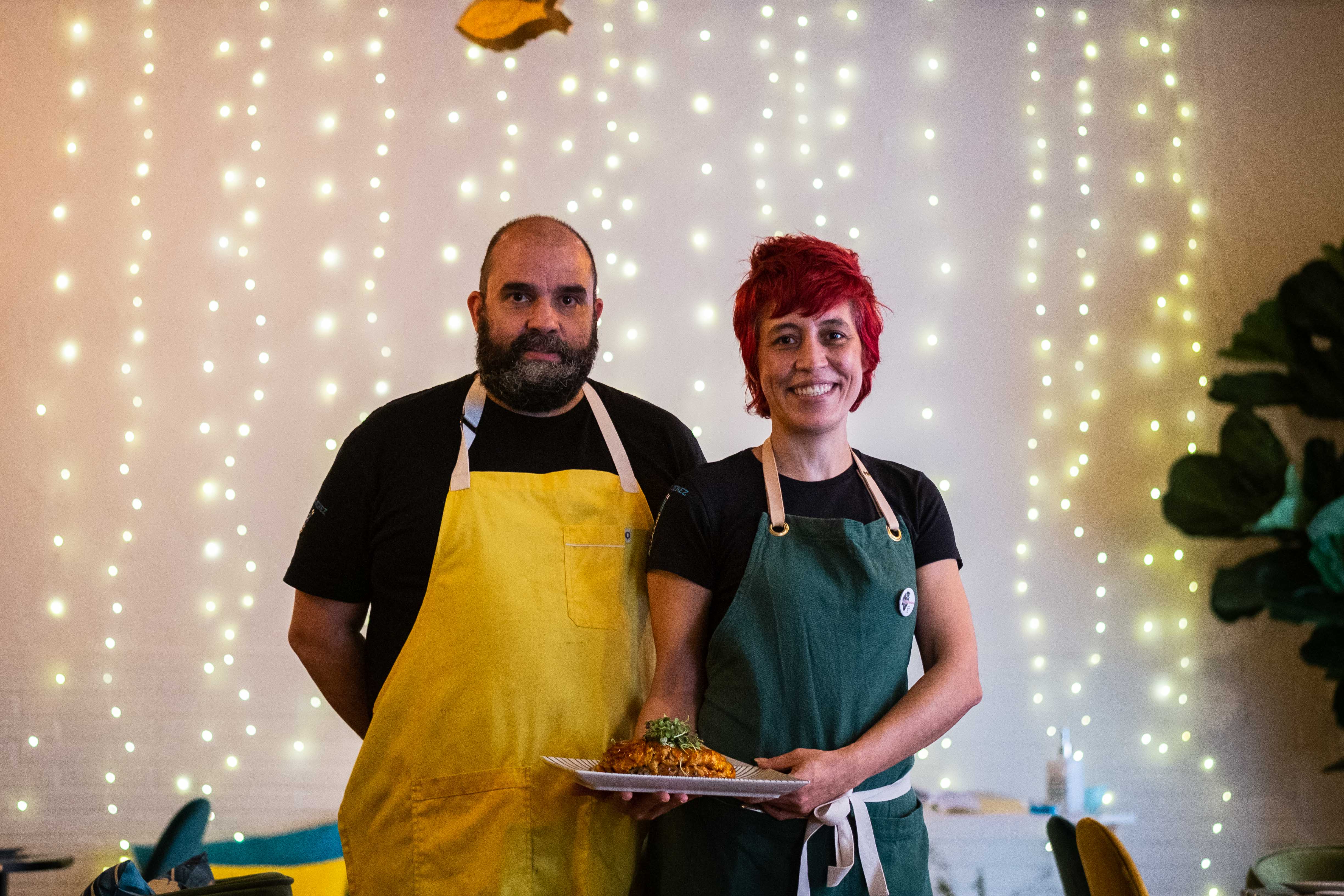 Javi Molero y Magda Quesada, en el interior de Kmarón Jerez y con un plato de pollo marinado entre manos.