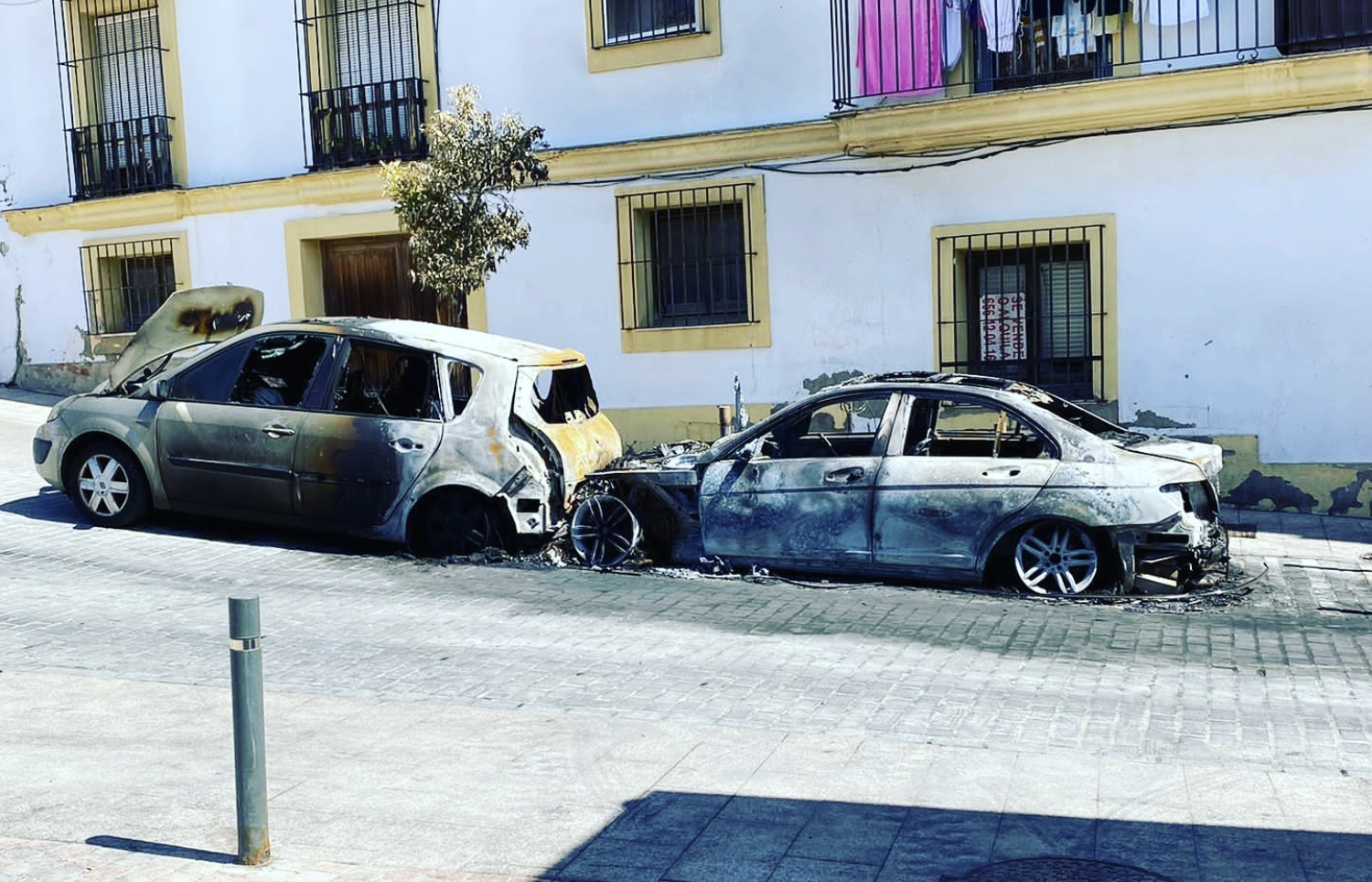 Coches incendiados junto a viviendas, en el entorno de la plaza Belén, en días pasados.