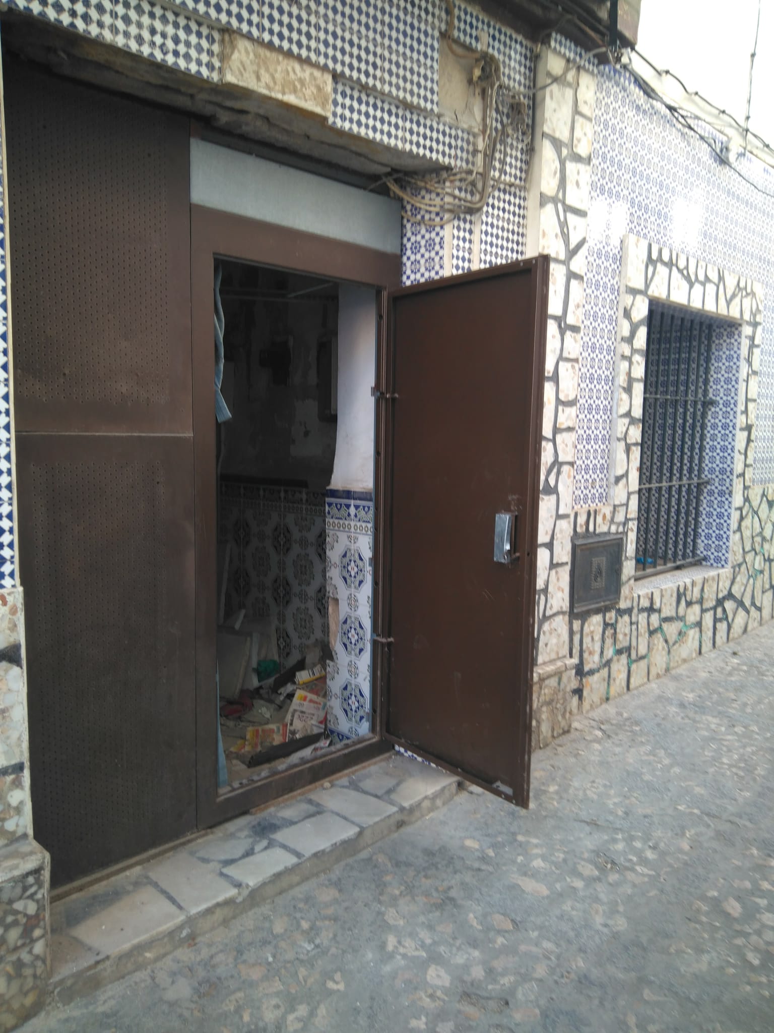 Una puerta 'antiocupa' reventada en el número 3 de la calle Salvador.