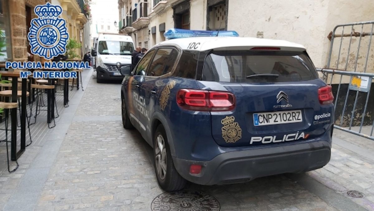 Un coche de la Policía en el lugar donde el herido se desplomó.