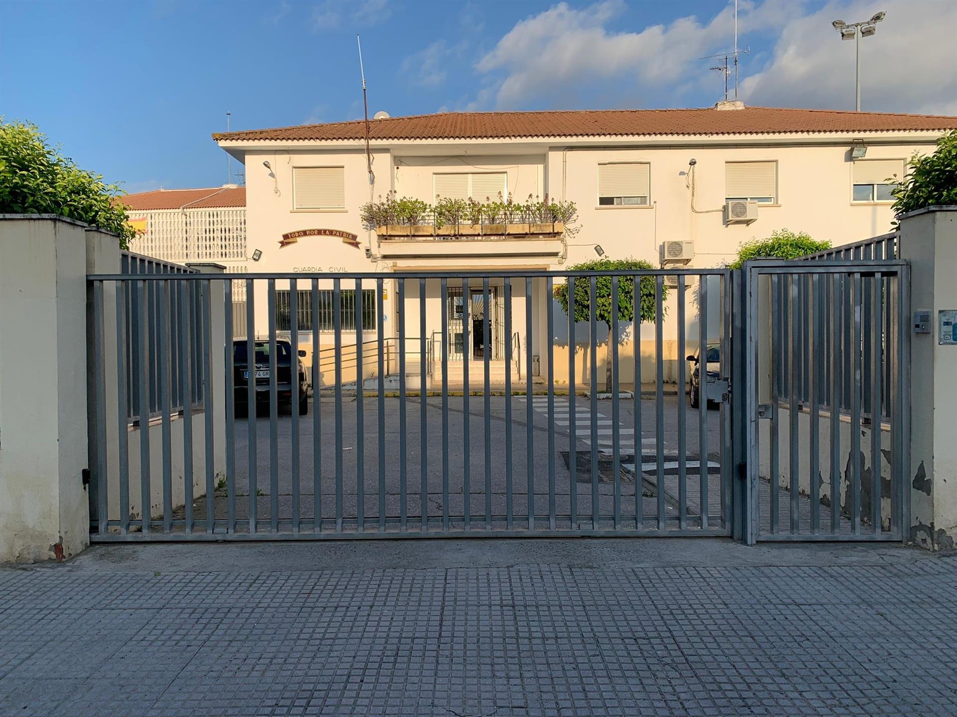 Acceso al cuartel de La Algaba, en Sevilla, donde un encapuchado se estampa con un coche robado contra la puerta.