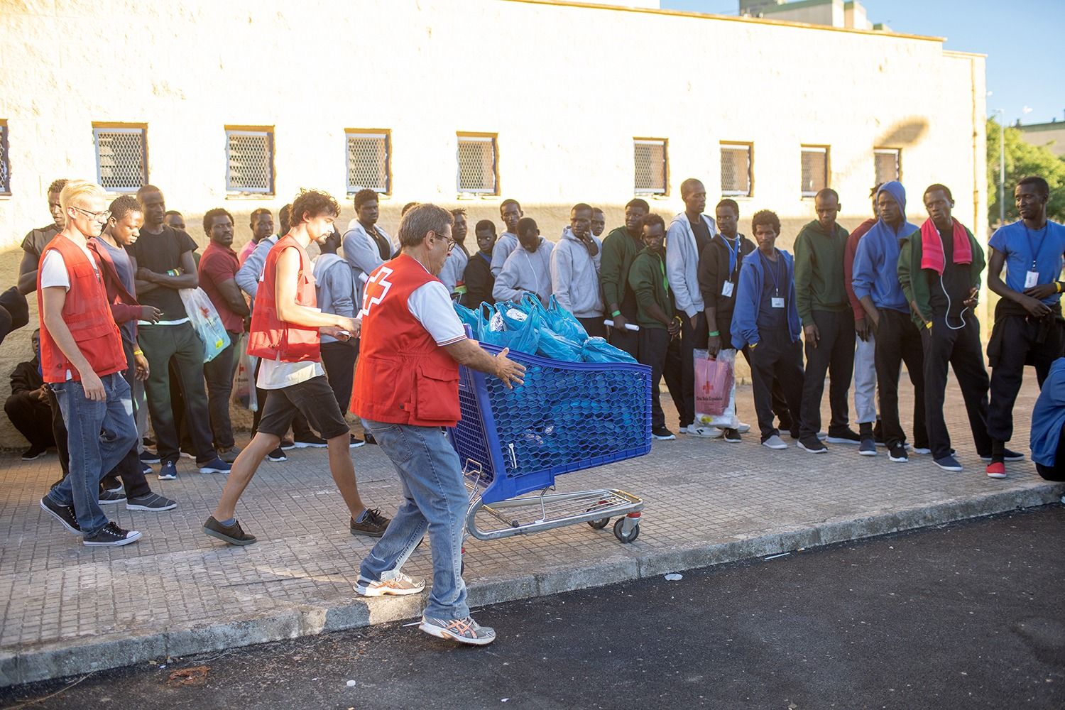 Inmigrantes a las puertas del polideportivo Kiko Narváez, con la asistencia de Cruz Roja. FOTO: JUAN CARLOS TORO. 
