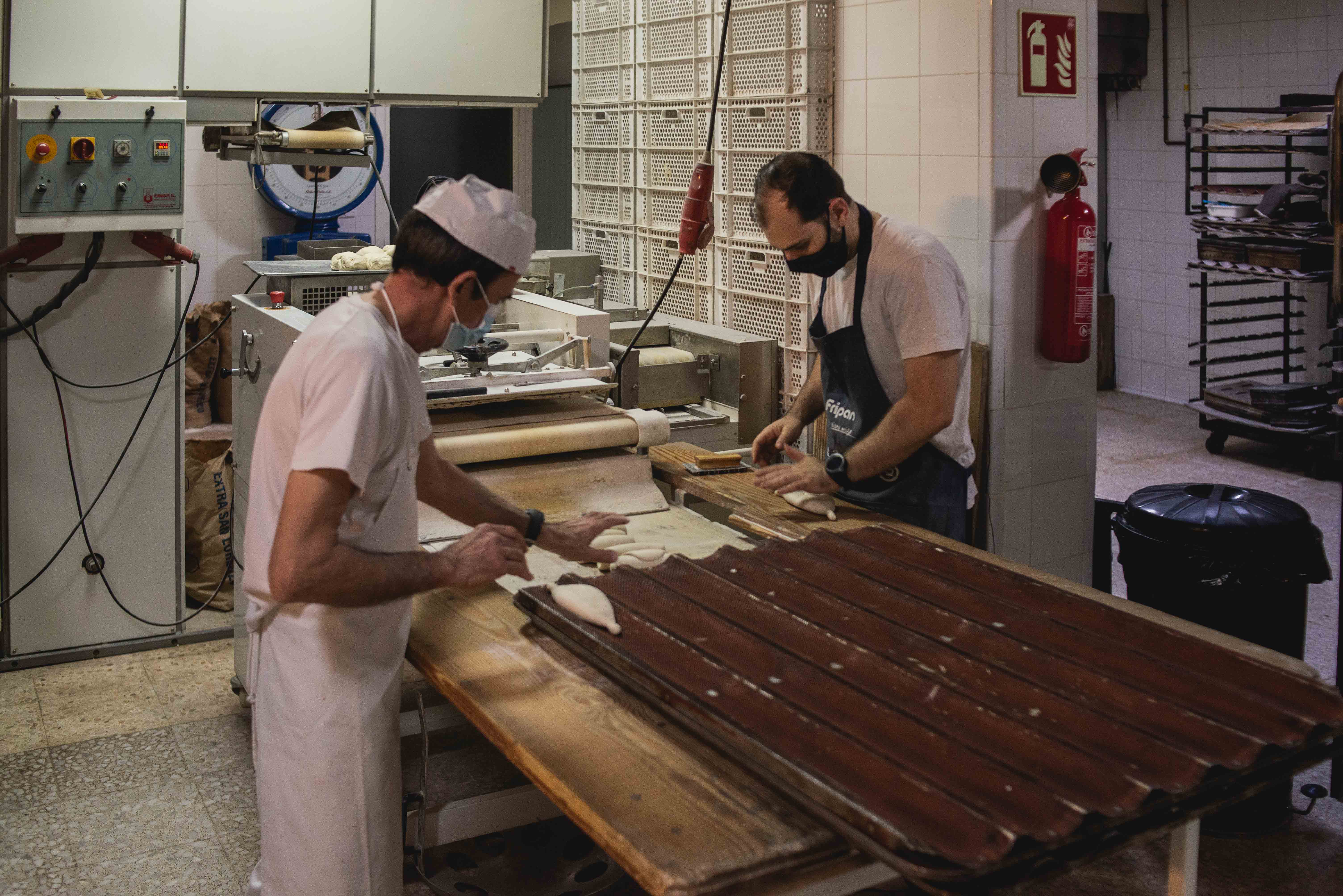 El maestro panadero Antonio junto a Álvaro en la panificadora.