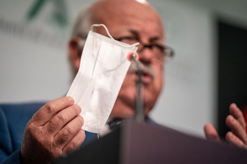 El consejero de Salud, Jesús Aguirre, con una mascarilla en la mano.