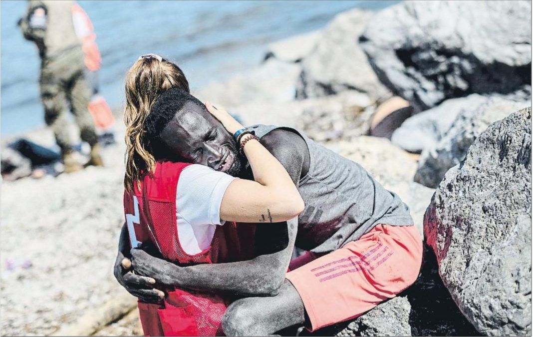 Luna, voluntaria de Cruz Roja, abrazando a un inmigrante en Ceuta.