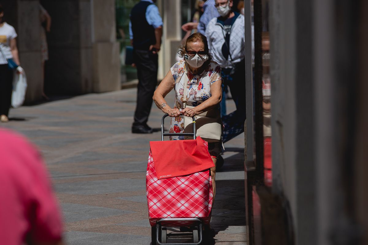 Una mujer, pasean con mascarilla por la calle, estos días.