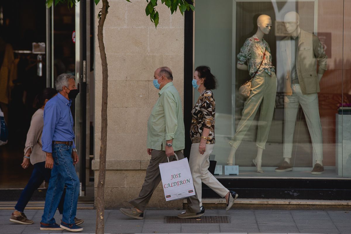 Personas pasean por la calle con mascarilla, en una imagen reciente.