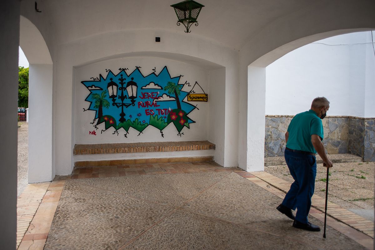 Una persona mayor pasea por un mural en el Jerez rural.