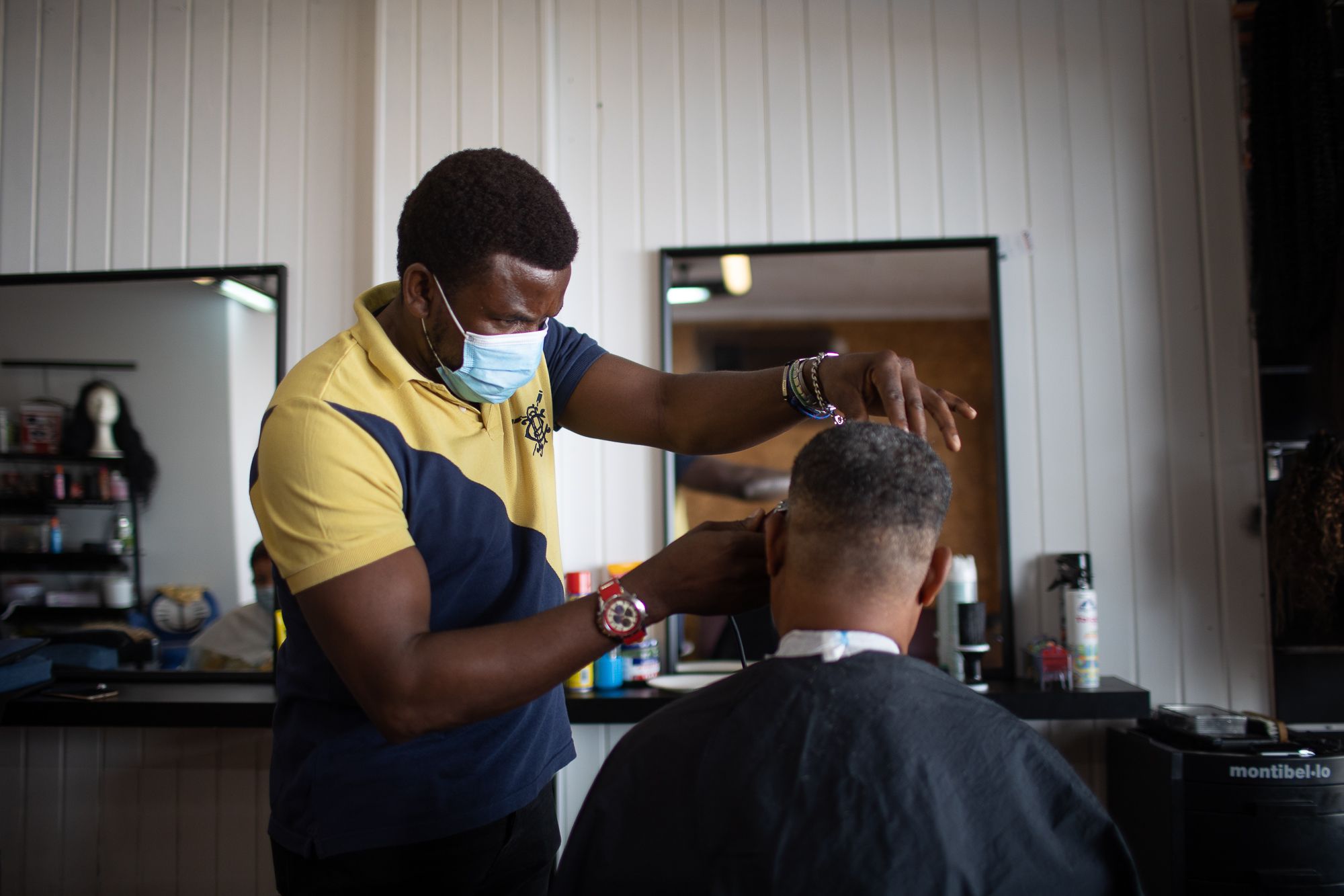 Christian Loris, pelando a un cliente en su peluquería, abierta en Jerez.