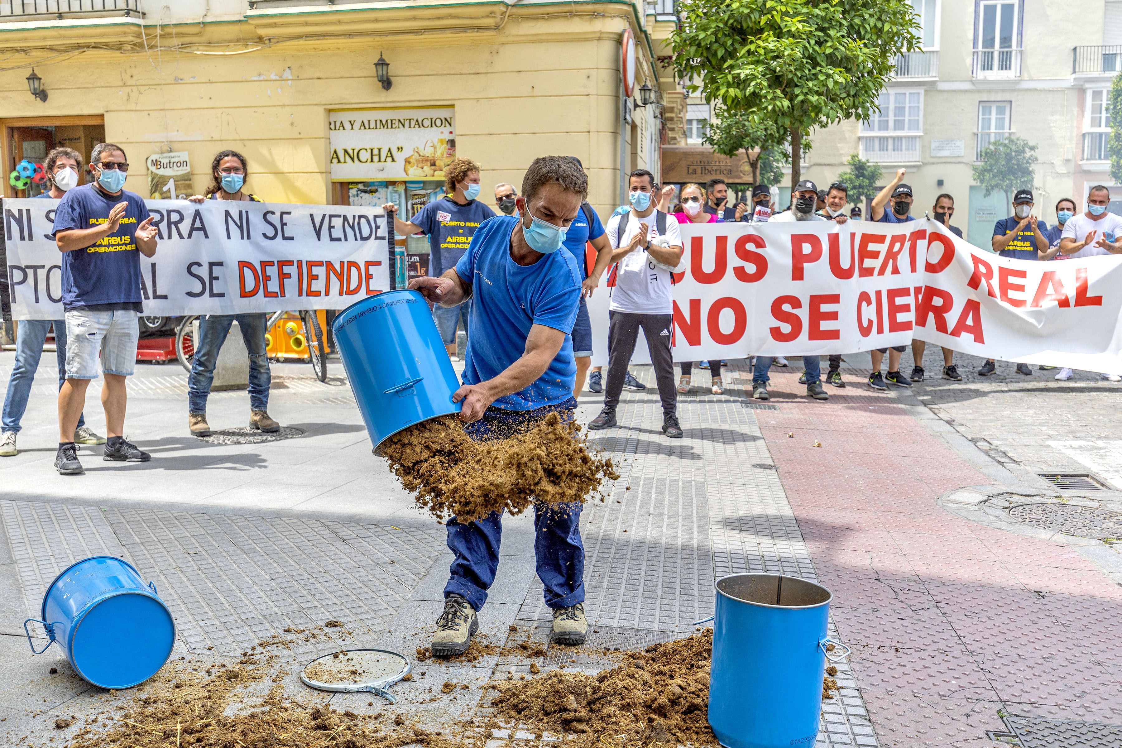 Un trabajador de Airbus derrama estiércol frente a la sede del PSOE en Cádiz.