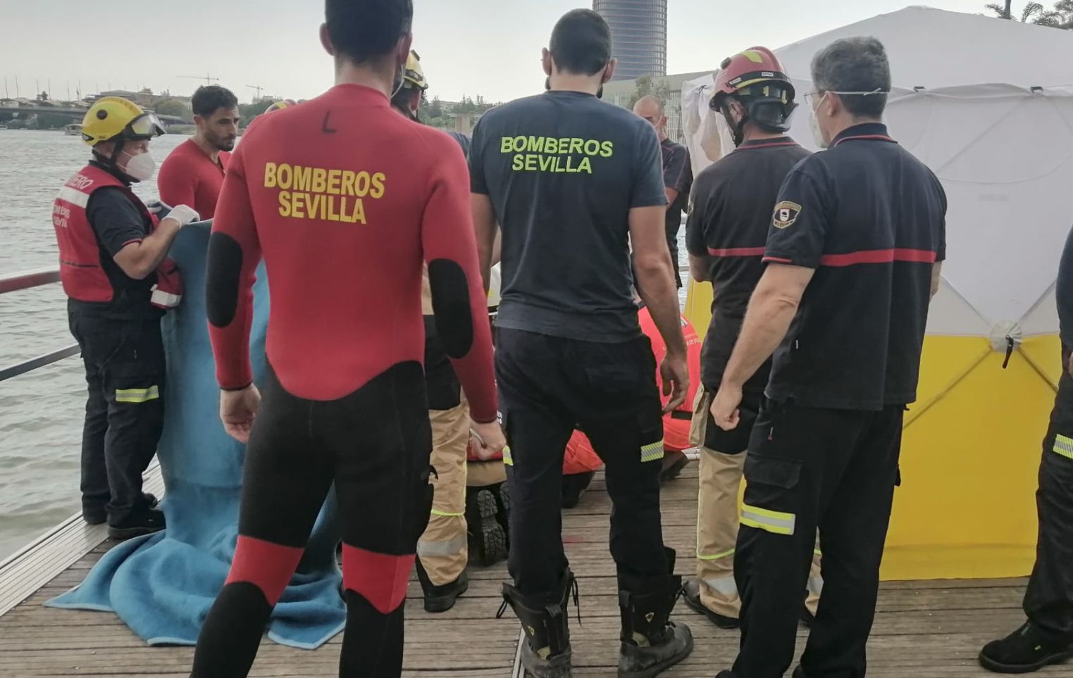 Personal de emergencias junto al cadáver del hombre encontrado en el Guadalquivir.