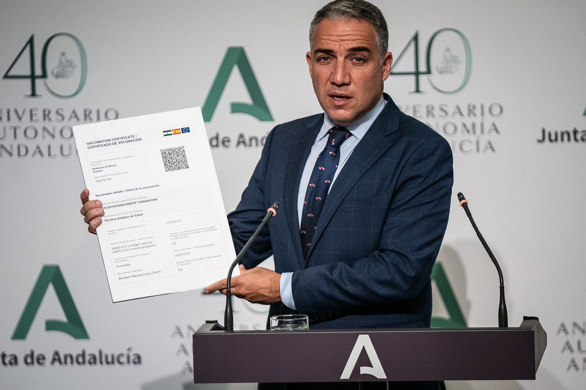 Bendodo, este martes, muestra un certificado de vacunación de los que expedirá Andalucía.