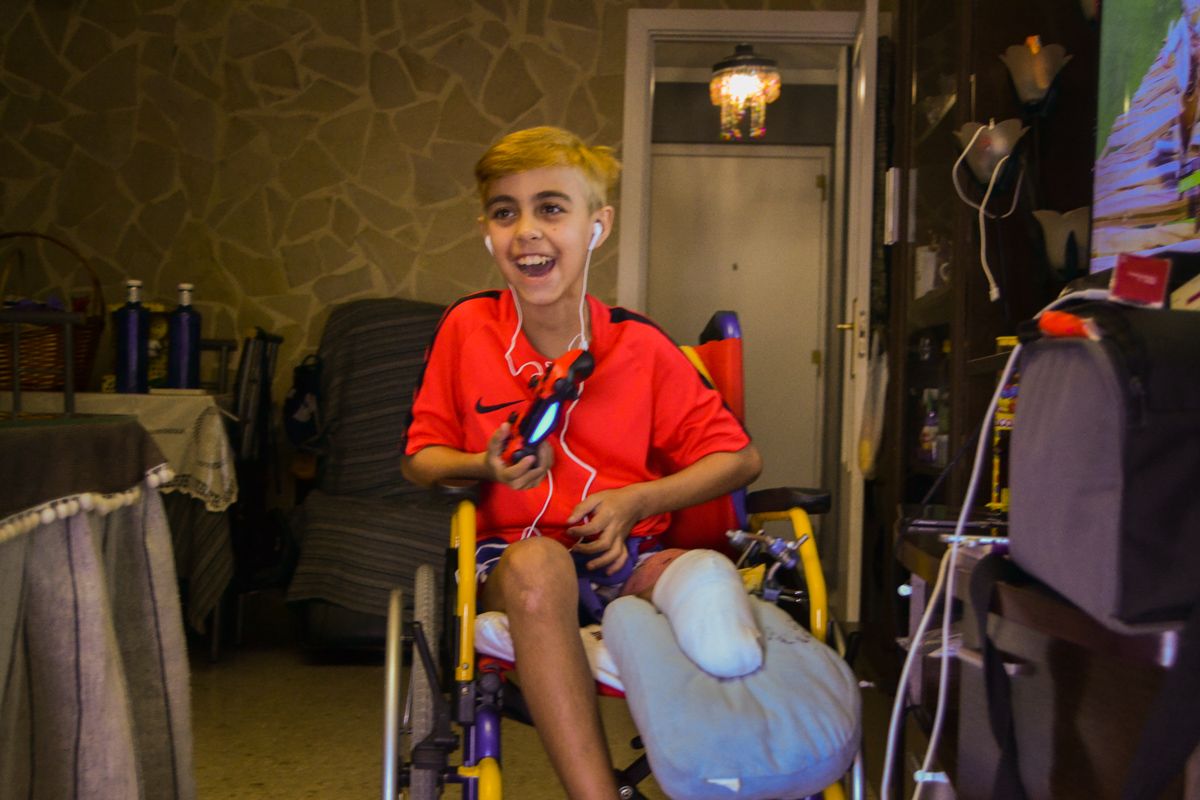 Aitor, en su casa, sonriendo mientras juega a la Play Station. FOTO: CLAUDIA GONZÁLEZ ROMERO